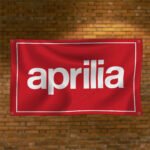 "Show your passion for motorcycles with the Aprilia Racing 3x5 ft flag banner. Perfect for motorcycle enthusiasts, this vibrant banner is ideal for garages, man caves, or wall décor. Made for indoor and outdoor use, it's a must-have for Aprilia fans and racing lovers."