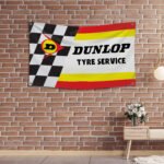 "Decorate your space with this 3x5 ft Dunlop Tyre Service banner flag, perfect for racing motorcycle enthusiasts and fans of high-performance tires. Featuring bold Dunlop branding and graphics, this durable banner is ideal for garages, man caves, workshops, or motorcycle shows. Made from high-quality materials, it’s designed for both indoor and outdoor use, ensuring vibrant colors and long-lasting appeal. Whether you’re showcasing your passion for motorcycle racing or highlighting the quality of Dunlop tyres, this banner is a must-have décor piece for any true fan of performance and durability."