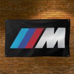 "Enhance your space with this 3x5 ft BMW M Power flag. Perfect for garages, shops, man caves, and wall décor, this durable banner features bold BMW Motorsport branding. Ideal for indoor and outdoor use, it’s a great sign for showcasing your passion for high-performance driving and BMW M Power’s legacy in motorsport."